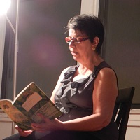 Photo of the presenter reading aloud from a book
